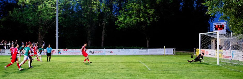 Jaroslav Machovec penalty shot vs Jozef Hros VI. Goal.: Jaroslav Machovec's hard penalty shot slams into the Monchof net as keeper  keeper Jozef Hros falls hard on the ground.VI Subject: Burgenland;Jaroslav Machovec;Jozef Hros;Kemal Kazanci;Kittsee;Monchof;football;soccer