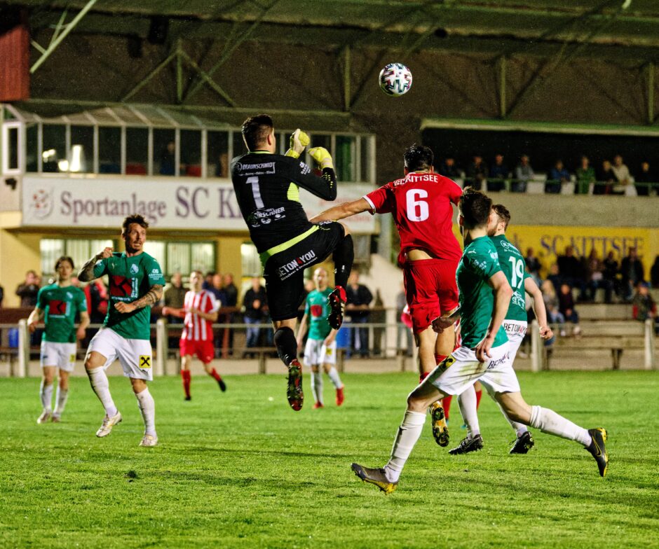 Jaroslav Machovec header: Another challenging header from Jaroslav Machovec. Jozef Hros must leap high to ward off the threat. A superhuman performance from Machovec all evening. Subject: Burgenland;Jaroslav Machovec;Jozef Hros;Kittsee;Monchof;football;soccer
