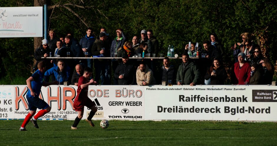 Thomas Werdenich flees Thomas Bastian: Kittsee home bench fans enjoy watching UFC Pama's Thomas Werdenich try to keep the ball away from Kittsee captain Thomas Bastian Subject: soccer;football;burgenland;kittsee;Thomas Bastian;Thomas Werdenich