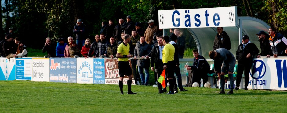 Sombat Penalty Sequence 21: Referee Markus Kouba asks UFC Pama coaching staff which player they would like to take off the field to allow them to field a keeper (with a red card, Julius Pentek does not get a substitute). He gets another earful from the UFC Pama clubman. Subject: soccer;football;burgenland;kittsee;Jozef Sombat;Julius Pentek;Andreas Roth;Markus Kouba