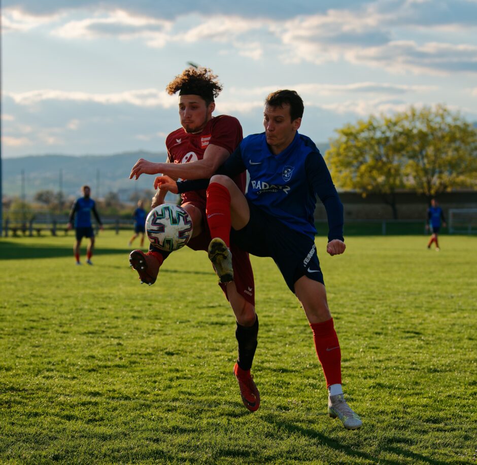 Patrick Pail and Simon Werdenich compete for a high ball: UFC Pama can't keep the ball out of their own end. SC Kittsee's Patrick Pail tries to take a high ball away from Simon Werdenich in front of the UFC Pama goal. Subject: soccer;football;burgenland;kittsee;Simon Werdenich;Patrick Pail