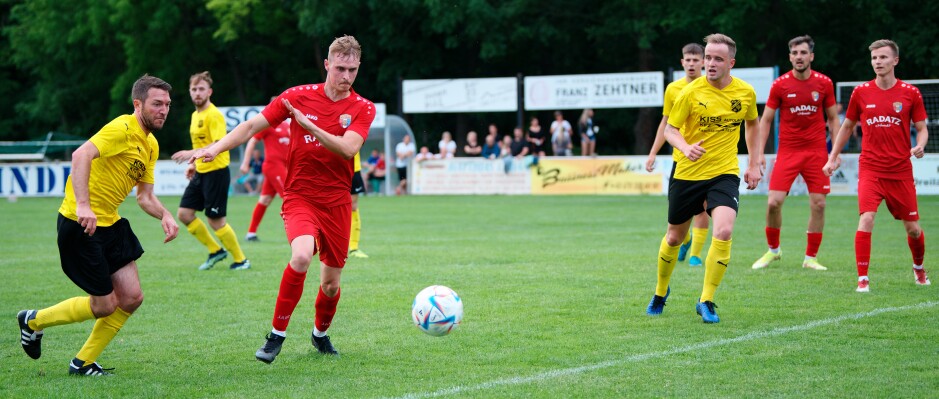 Sombat kick 2: Jozef Sombat winds up to hammer the ball on the bounce, as Katzler continues to give chase. Subject: soccer;football;burgenland;kittsee;ASV Jahrndorf;Mario Katzler;Jozef Sombat