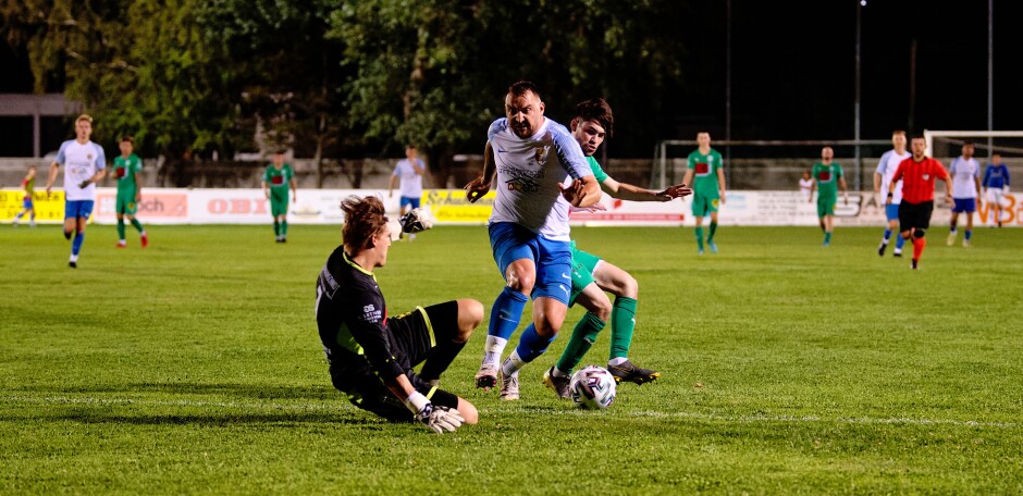 Bombicz barrels past defender Florian Karner: Stefan Josef Könnyü is sprawled on the ground but somehow manages to stop Bombicz Subject: soccer;football;burgenland;kittsee;SC Kittsee;FC Monchof