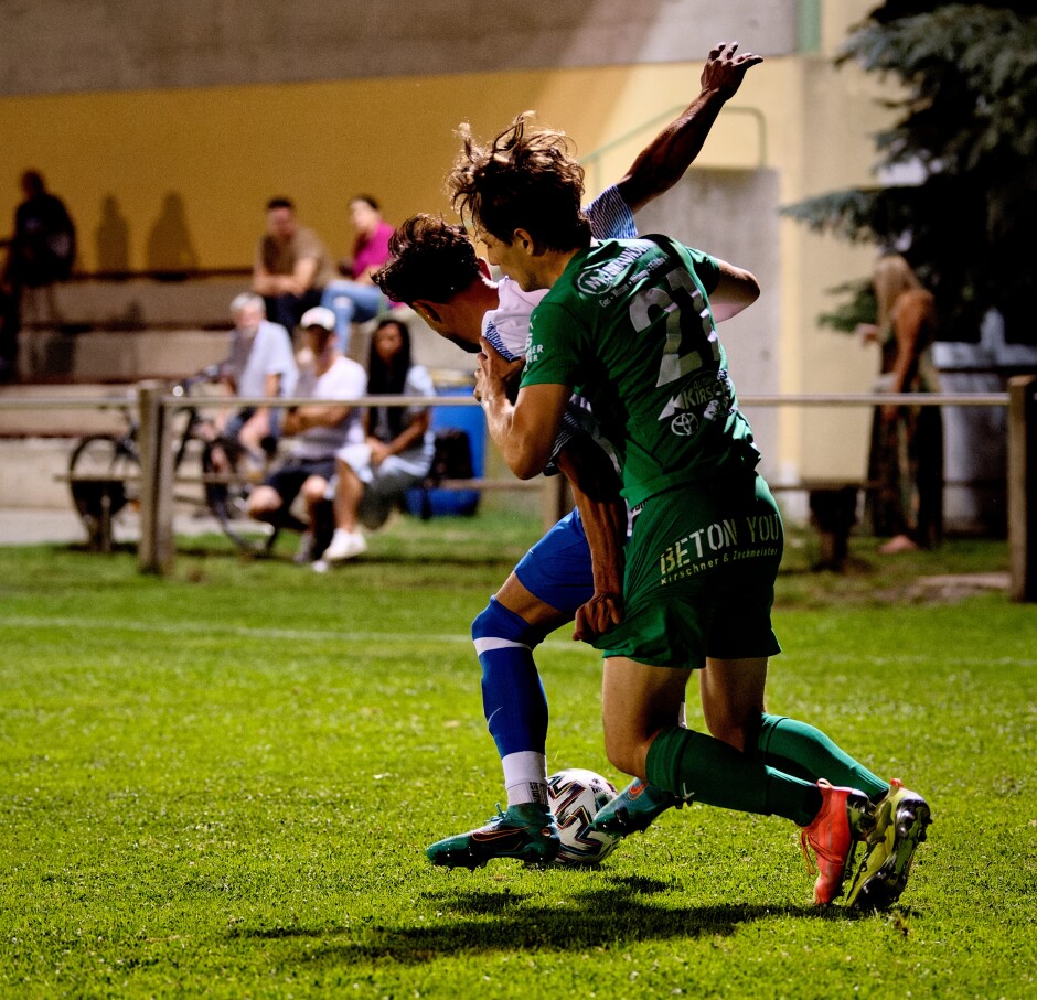 Mustafa Atik and Elias Luisser wrestle for the ball 1: This is a sequence. Note the hard shorts pull from Atik. Subject: soccer;football;burgenland;kittsee;SC Kittsee;FC Monchof