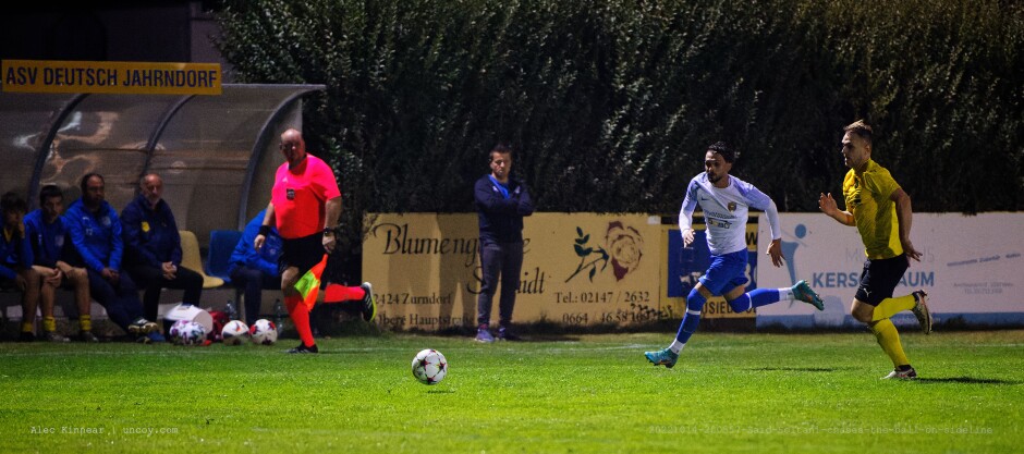 Said Soltani chases the ball on sideline: In a foot race, Said Asharaf Soltani ends up outrun by Stanislav Ducar while Deutsch Jahrndorf coach Rene Hoffmann observes and linesman Stefan Bauer runs with the action. Subject: SC Kittsee;ASV Deutsch Jahrndorf;II Liga Nord;Burgenland;soccer;football;Said Asharaf Soltani;Stanislav Ducar;Rene Hoffmann;Stefan Bauer