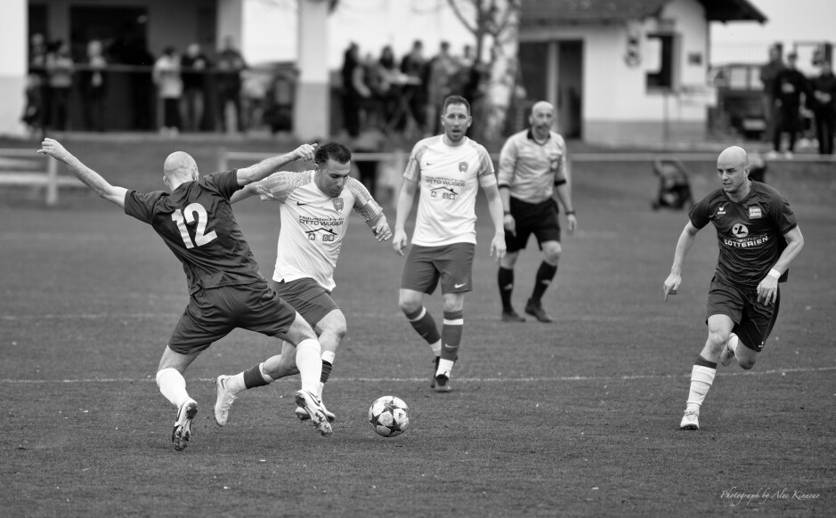 Mustafa Atik drives past Peter Gallus: Peter Gallus tried to kick the legs out from under Mustafa Atik here. In honour of Gallus playing like a pirate all afternoon, let's call him red beard. Atik took a nasty tumble on what was a promising dribble. A free kick was too light a reward for the tripping. Yellow card would have been more suitable. Gallus did finally get his yellow card at 31 minutes. Subject: soccer;football;burgenland;kittsee;Peter Gallus;Mustafa Atik