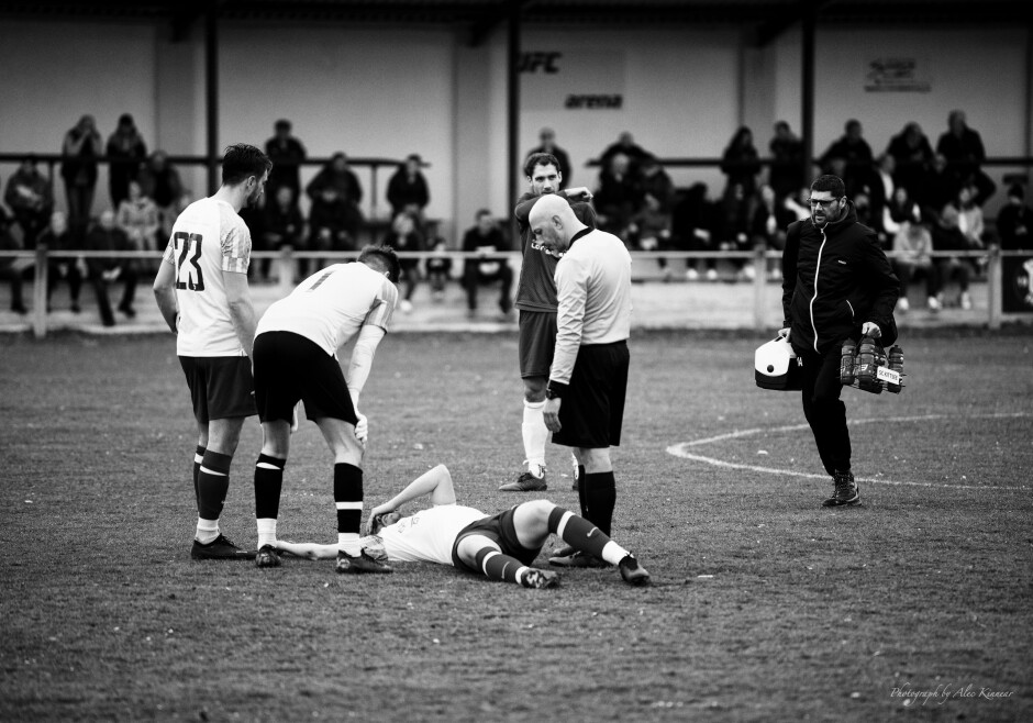 Tomas Bastian lies motionless: Kittsee trainer Radovan Liska runs to resuscitate Tomas Bastian after Peter Gallus's elbow to the head. Referee Arif Erdem looks on. Gallus certainly should have received a second yellow card and a red card after this unprovoked attack. Subject: soccer;football;burgenland;kittsee;Tomas Bastian;Radovan Liska;Arif Erdem