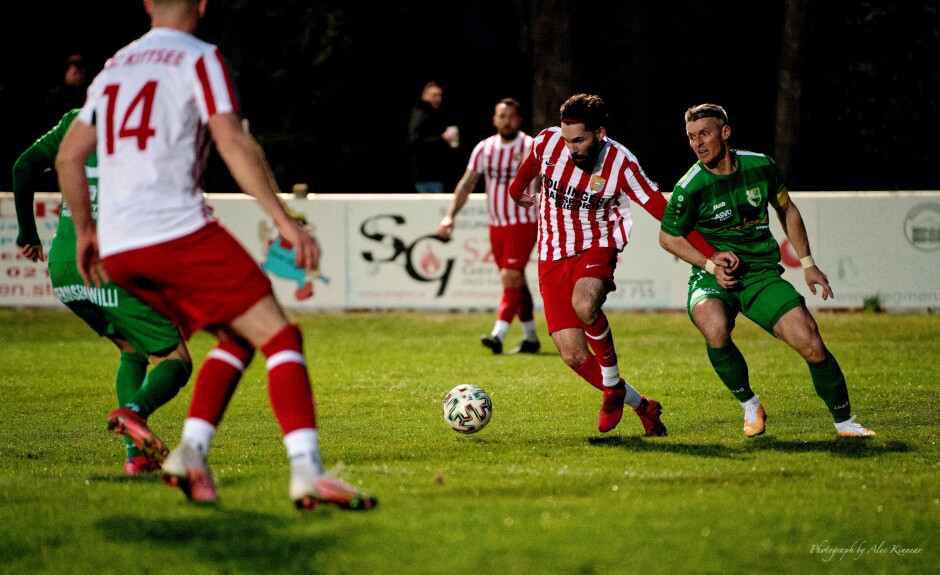 Fuska slips past Speckl in another net rush: Michael Speckl tugs at Juraj Fuska's hand to attempt to knock him off stride Subject: soccer;football;burgenland;kittsee;SC Kittsee;FC Winden;Michael Speckl;Juraj Fuska