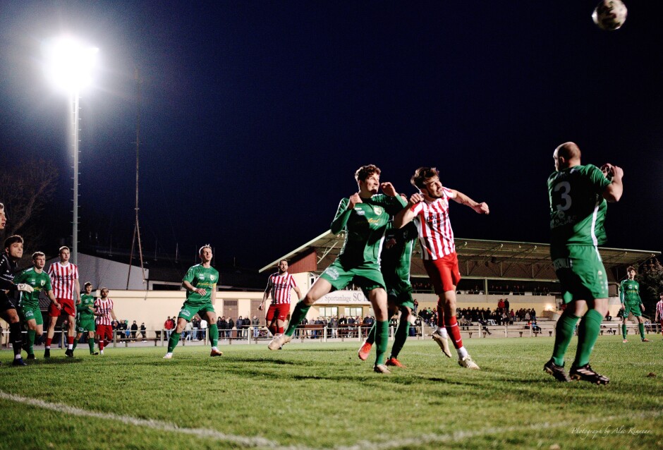 Balazi competes with Machovec for a header: Filip Balazi attempts to block Jaroslav Machovec  from a header in front of the FC Winden net where Roman Ostojic and Marek Luscik wait for the shot. Subject: soccer;football;burgenland;kittsee;SC Kittsee;FC Winden;Filip Balazi;Jaroslav Machovec