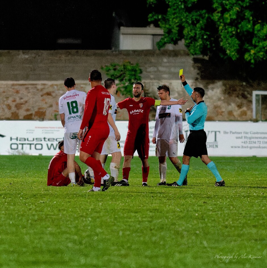 Stefan Andert sees a yellow card for another hard tackle on Said Soltani: Here field captain Patrick Dietmann raises his hands in outrage, real or imagined. Three similar players from Pamhagen received yellow cards for hard tackling. Brothers Alexander Andert and Stefan Andert, and of course David Fleischhacker. Kittsee had no shortage of yellow cards, but mostly for complaining (Captain Michael Wernecker, alternate captain Tomas Bastian). Subject: Kittsee;Pamhagen;SK Kittsee;UFC Pamhagen;soccer;football;Said Soltani;David Fleischhacker;Patrick Dietmann;Erdem Sahin