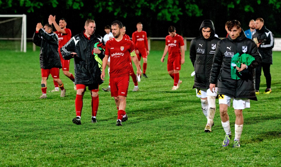 Tomas Bastian explains the yellow armband to Patrick Dietmann: With both Tomas Bastian and Michael Wernecker substituted out, Dietmann wore the captain's yellow armband. Bastian explains that the captain's role is to prevent a brawl breaking out, not to instigate one. Manuel Schopf and Stefan Andert glare as they leave the field. Mustafa Atik and Jaroslav Machovec clap the fans in the background. The joy of winning and the despair of defeat. Subject: Kittsee;Pamhagen;SK Kittsee;UFC Pamhagen;soccer;football;Jozef Sombat;Tobias Wisak;Jaroslav Machovec;Tomas Banovic;Said Soltani;Manuel Schopf;Stefan Andert;Mustafa Atik