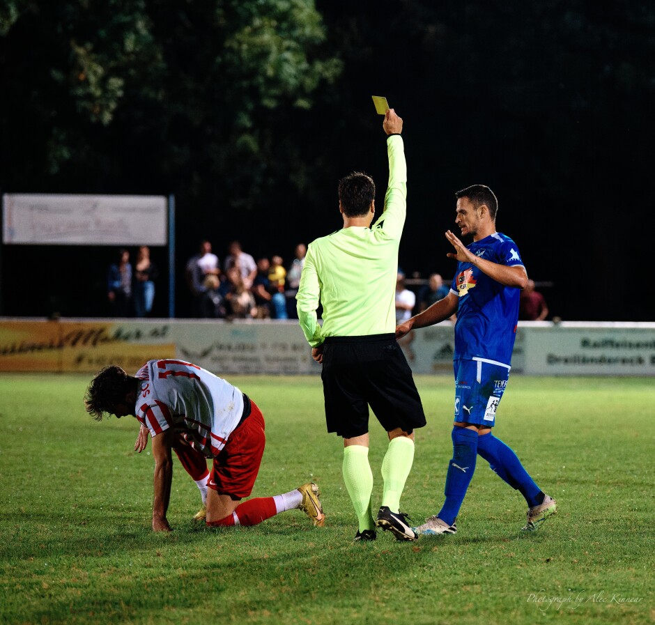 Shirt tackle: Image 3/3: Fortunately referee Claus Wisak was paying attention and gave Patrik Petrak the yellow card he deserved. Petrak arrogantly waves the referee off with his hand as Nagy tries to pull himself back to his feet. Subject: SC Kittsee;SV Gols;burgenland;football;kittsee;soccer