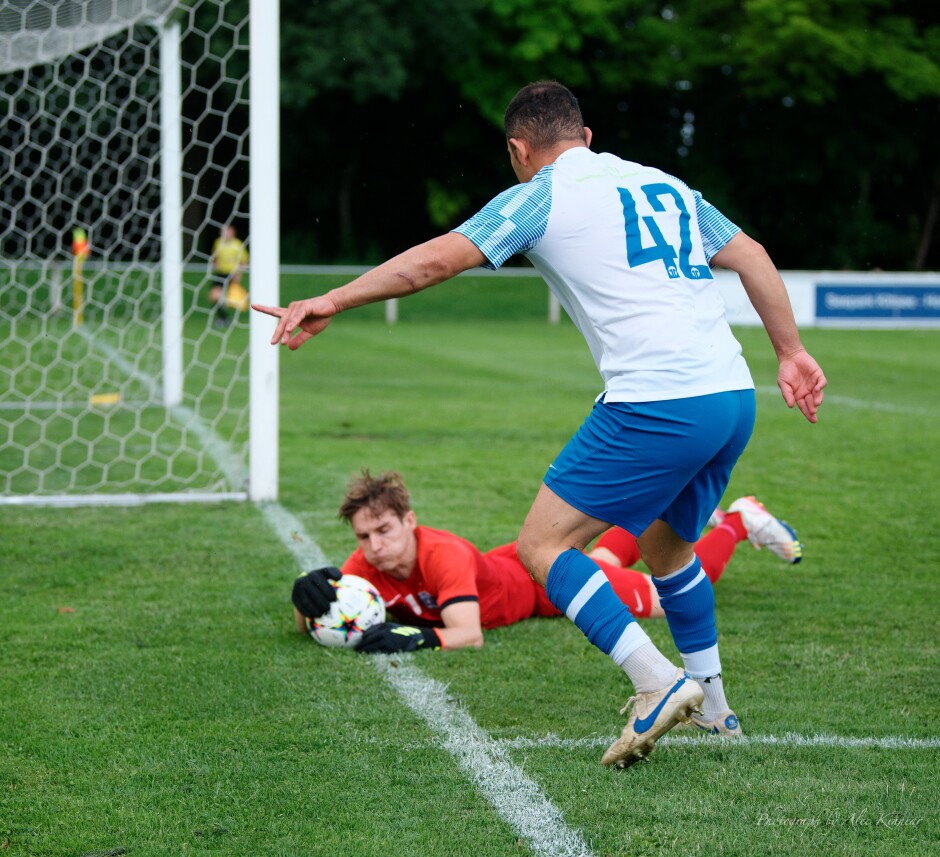 Keeper Lukas Mock gets to the ball first: Atik attempts to signal the ball is over the line. Strangely in soccer, almost over the line is still in. Subject: SC Kittsee;UFC Tadten;burgenland;football;kittsee;soccer