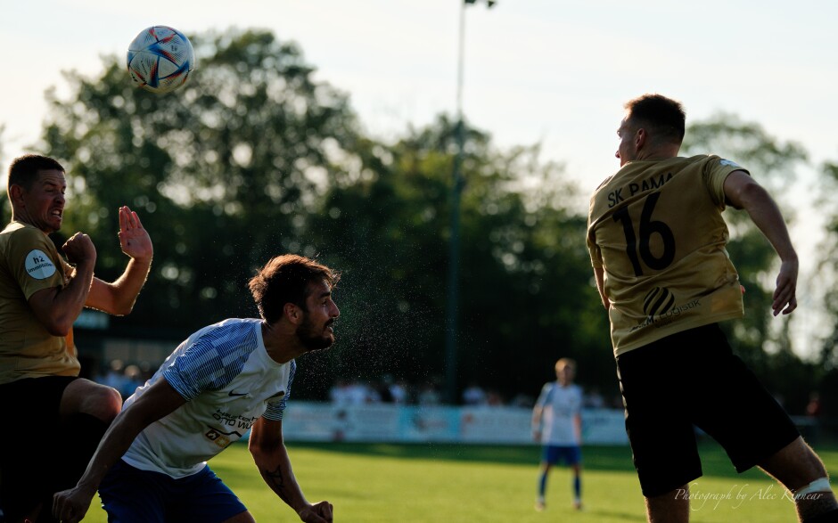 Sweat spatters on a hot day: Jaroslav Machovec headed the ball here as thousands of tiny droplets from his exertions in the afternoon heat fill the air with rainbow coloured drops. Machovec continue to be a one-man wrecking crew for SC Kittsee. Subject: soccer;football;burgenland;kittsee;SC Kittsee;UFC Tadten