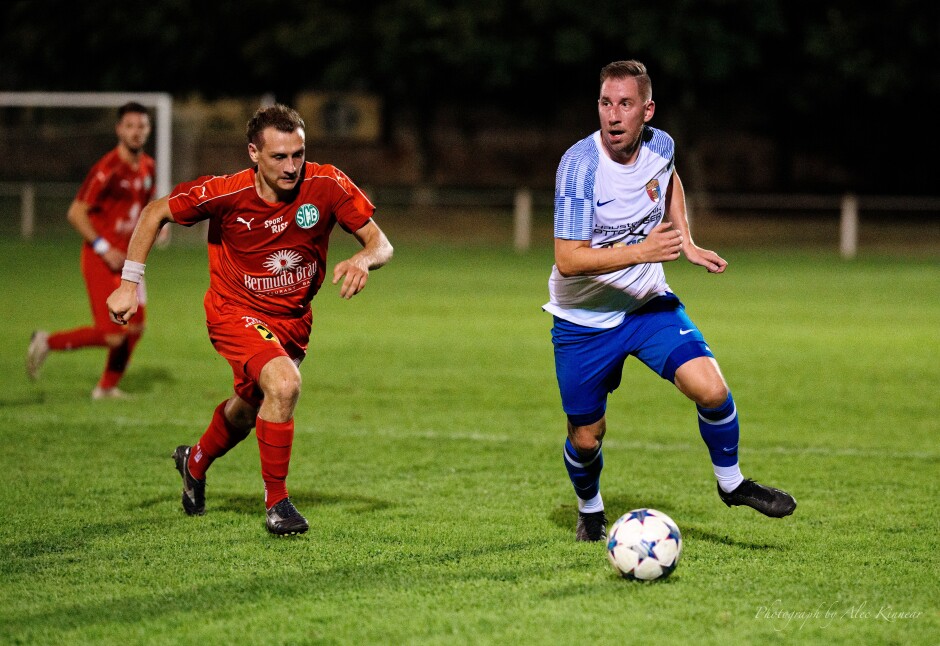 Captain Tomas Bastian seeks to build a play with Julian Millner in pursuit: Bastian took a yellow card at 34' and and was substituted at 51'. Good idea to get the yellow cards off the field in a stroppy, tight game. Subject: soccer;football;burgenland;kittsee;SC Kittsee;SC Breitenbrunn