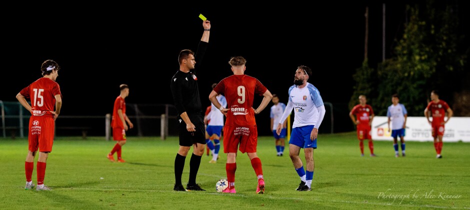 Nikica Veselcic shows Juraj Fuska a yellow card: Martin Hudak had a clear run at the SC Kittsee net so Fuska simply grabbed him and puilled him down. It was well outside the box so it's just a free kick. Fuska wisely took one for the team. Fuska doesn't get a lot of yellow cards so his eyes are round. Subject: soccer;football;burgenland;kittsee;SC Kittsee;SC Breitenbrunn;Juraj Fuska;Martin Hudak;Nikica Veselcic