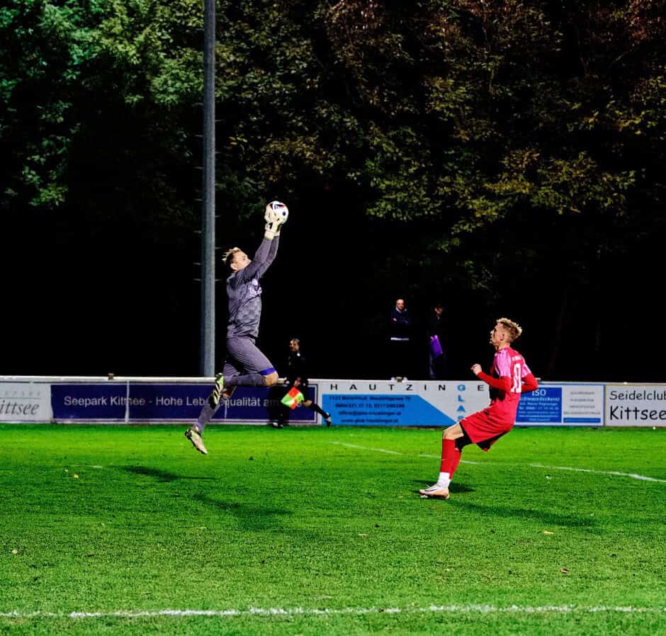 Unger leaps high for the ball, in front of Jozef Sombat: Jozef Sombat dallied regularly near the net, keeping Michael Unger on his toes. Subject: soccer;football;burgenland;kittsee;SC Kittsee;ASV Deutsch Jahrndorf