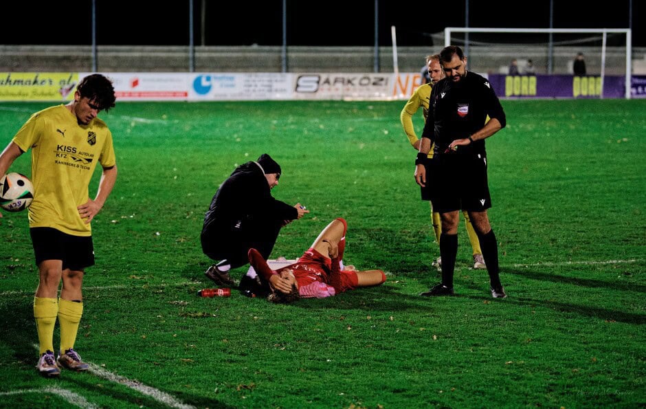 MIchal Belko takes cold spray after hard tackle: Carsten Lang looks on while ref Nevrez Cetiner checks extra time allowance. Restless Borys Brydniak awaits his throw-in. Subject: soccer;football;burgenland;kittsee;SC Kittsee;ASV Deutsch Jahrndorf