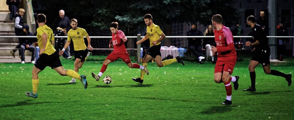 Mikula run: Maximilian Mikula runs through three Deutsch Jahrndorf attackers to clear the ball. Substitute Thomas Bastian shows off his fresh legs waiting for a pass.  Subject: soccer;football;burgenland;kittsee;SC Kittsee;ASV Deutsch Jahrndorf